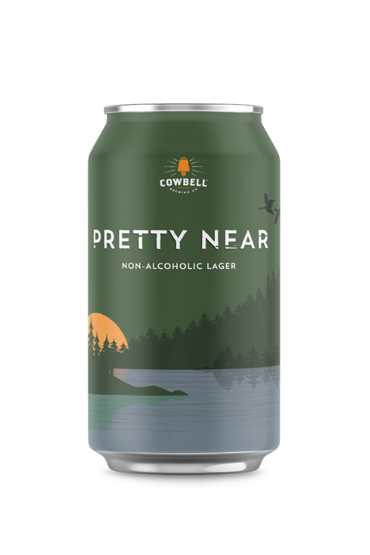 A can of Cowbell Brewing Co. Pretty Near Non-Alcoholic Lager with a green color scheme and a mountain-like design.